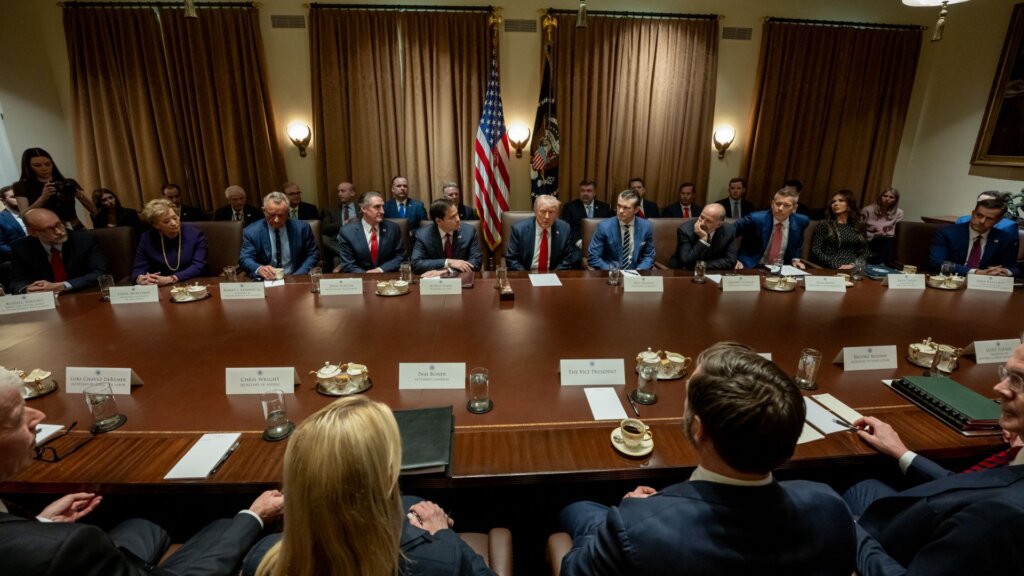 President Donald Trump meets with officials around a conference table at the White House.