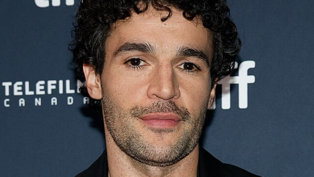 Christopher Abbott poses for a portrait with a navy blue backdrop.