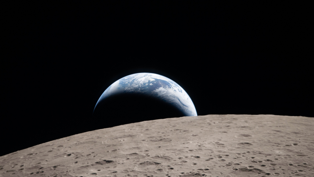 The blue and white marble of Earth peeks over the curved, cratered horizon of the Moon's surface against the black void of space..