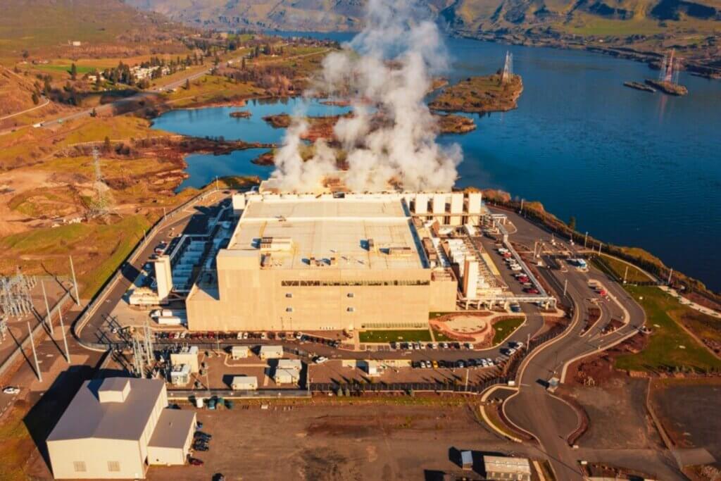 Aerial view of Google data center campus with steam rising from cooling systems along the Columbia River in The Dalles, Oregon.