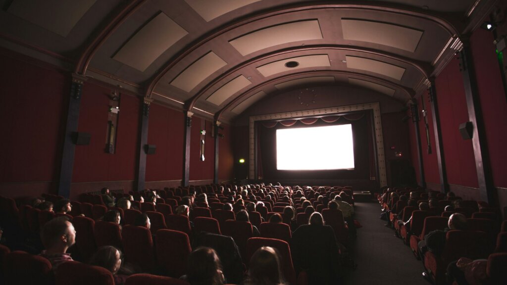 Movie theater full of people watching a movie.
