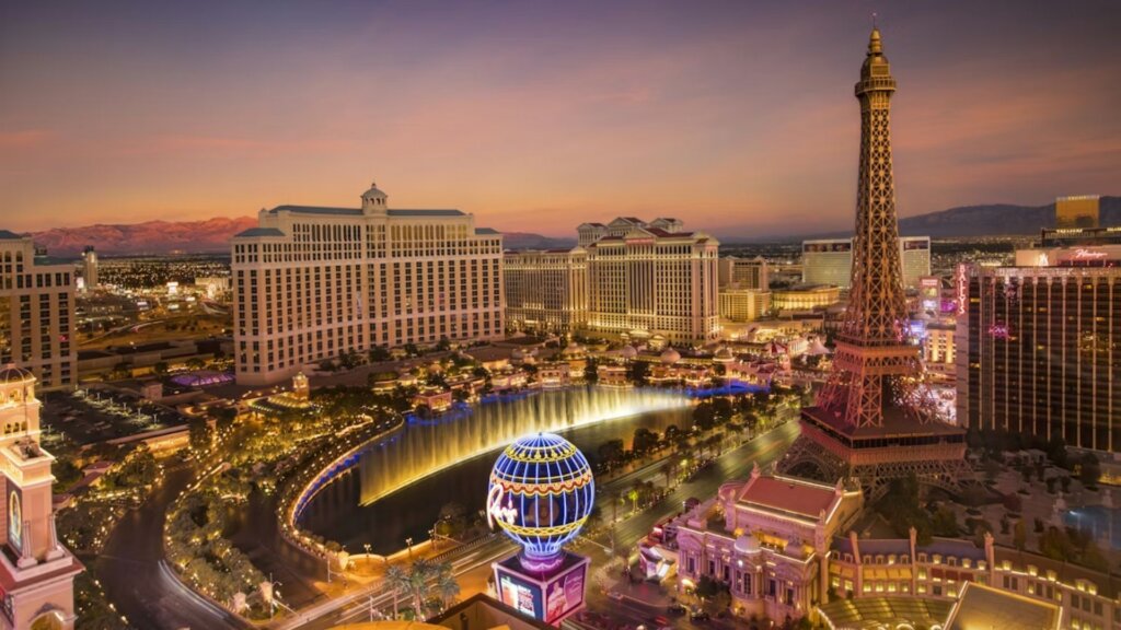 Aerial view of the Las Vegas Strip at dusk with Bellagio fountains and Paris casino replica Eiffel Tower.