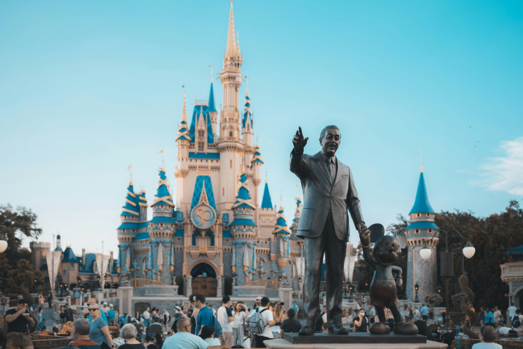 Statue of Walt Disney and Mickey Mouse in front of Cinderella Castle at Disney theme park.