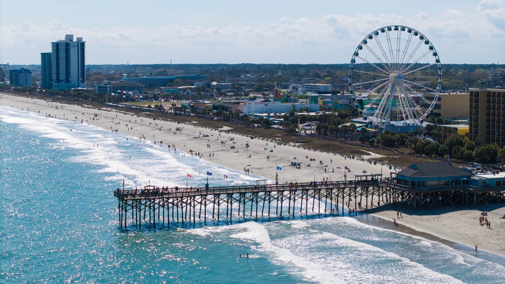 Myrtle Beach coastline with a pier, Ferris wheel, and beachfront hotels along the South Carolina shore.