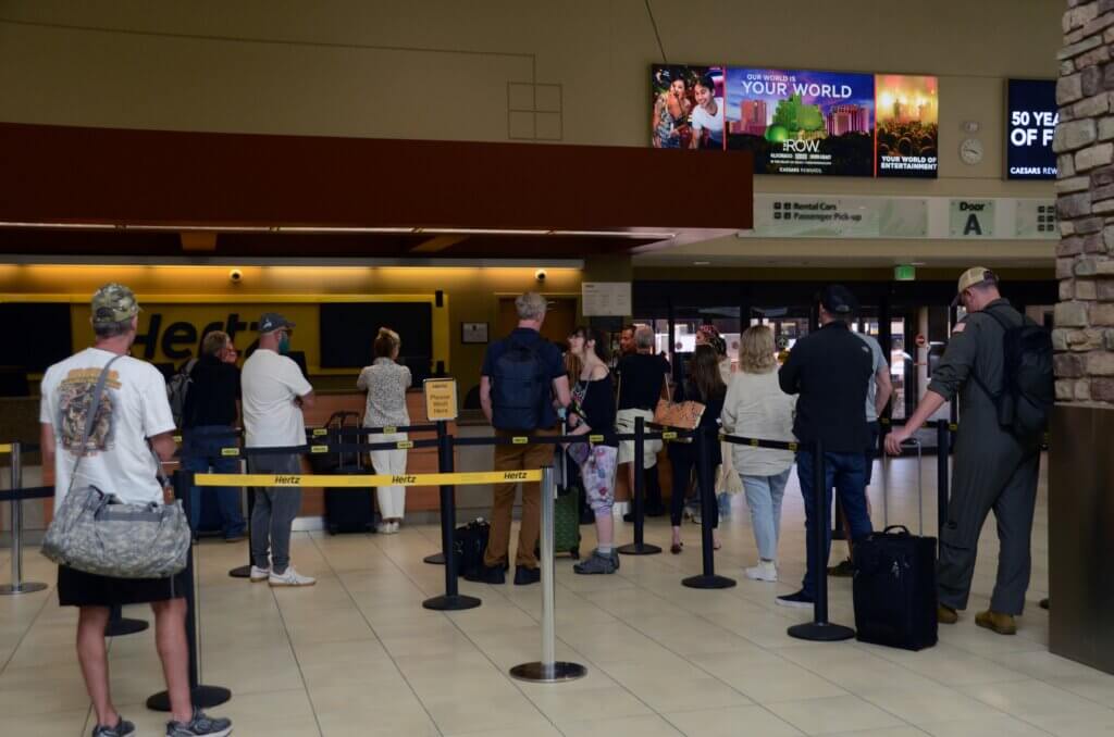 Travelers waiting in line inside airport.