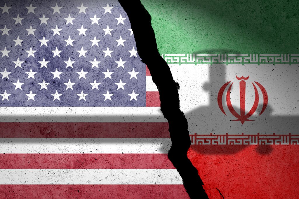 Split image of U.S. and Iranian flags with a crack between them, symbolizing conflict or division.