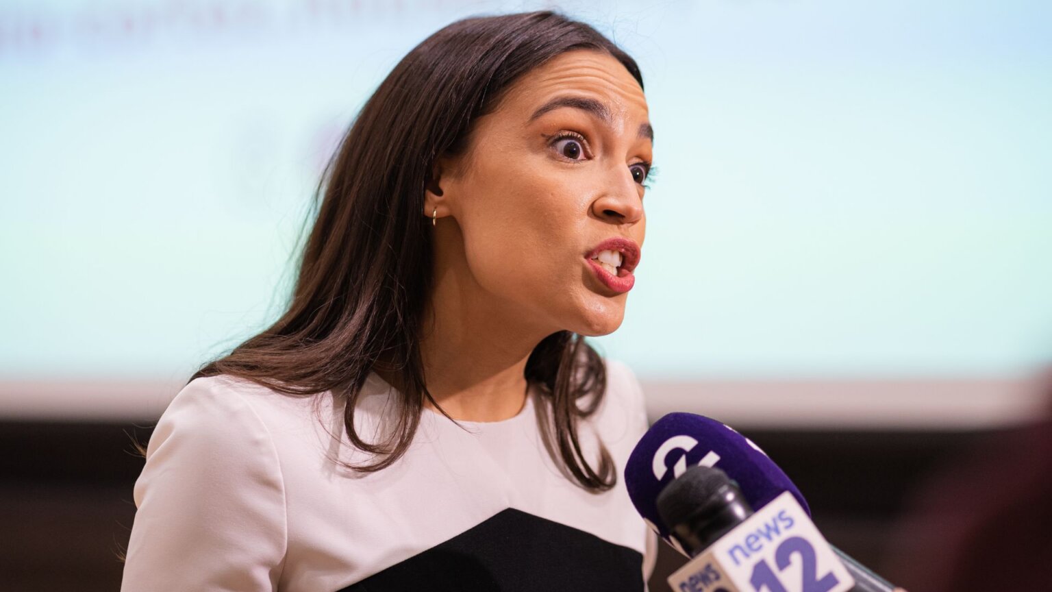 AOC: No One Truly “Earns” a Billion Dollars, You Just Can’t Alexandria Ocasio Cortez speaks emphatically into a microphone during a public event.