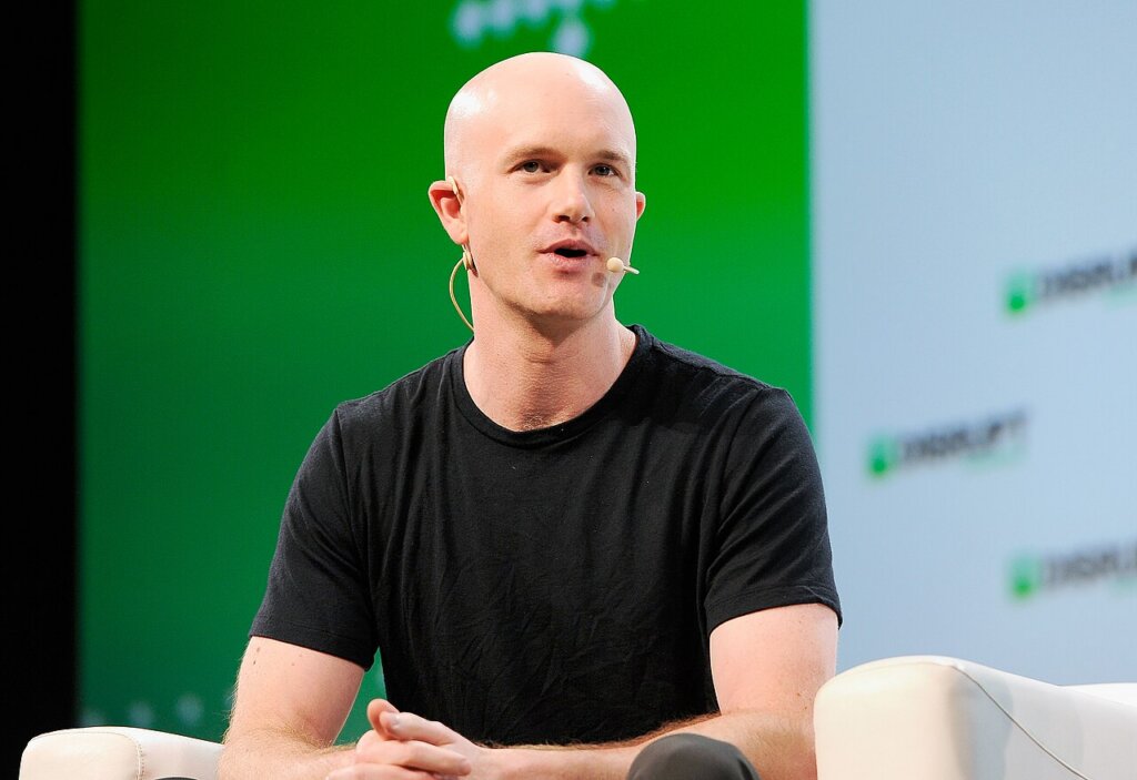 Coinbase CEO Brian Armstrong speaking onstage at an event.
