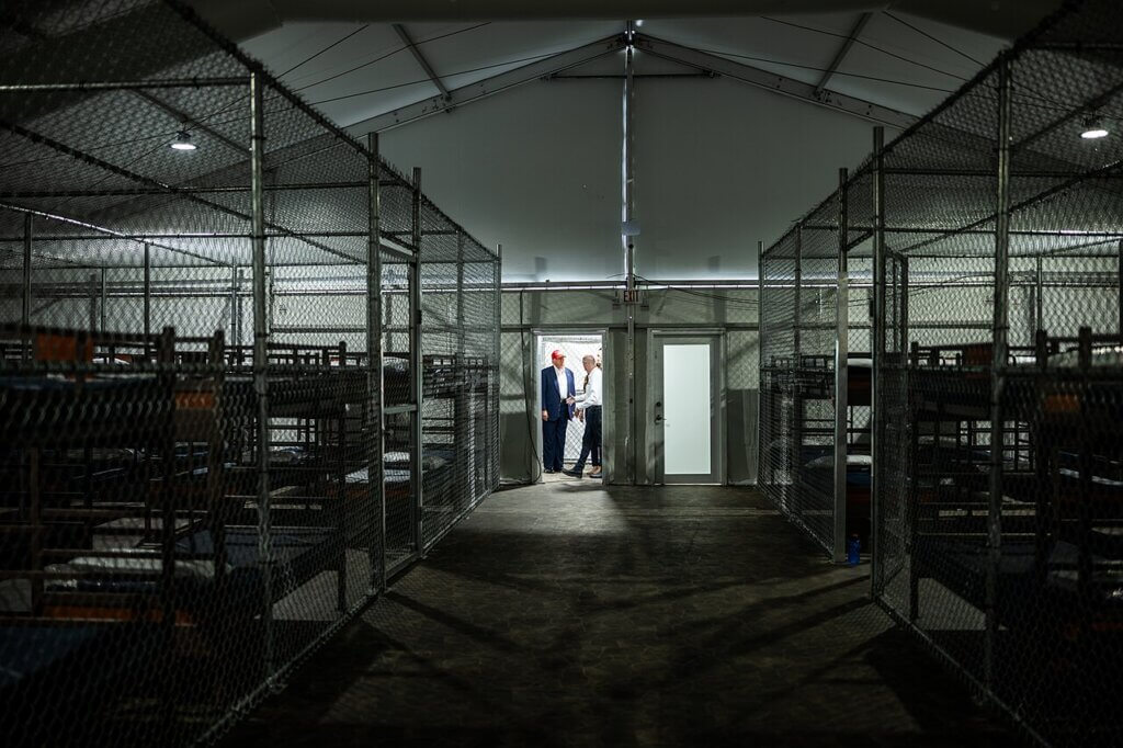 Interior of Alligator Alcatraz, with President Donald Trump in the background