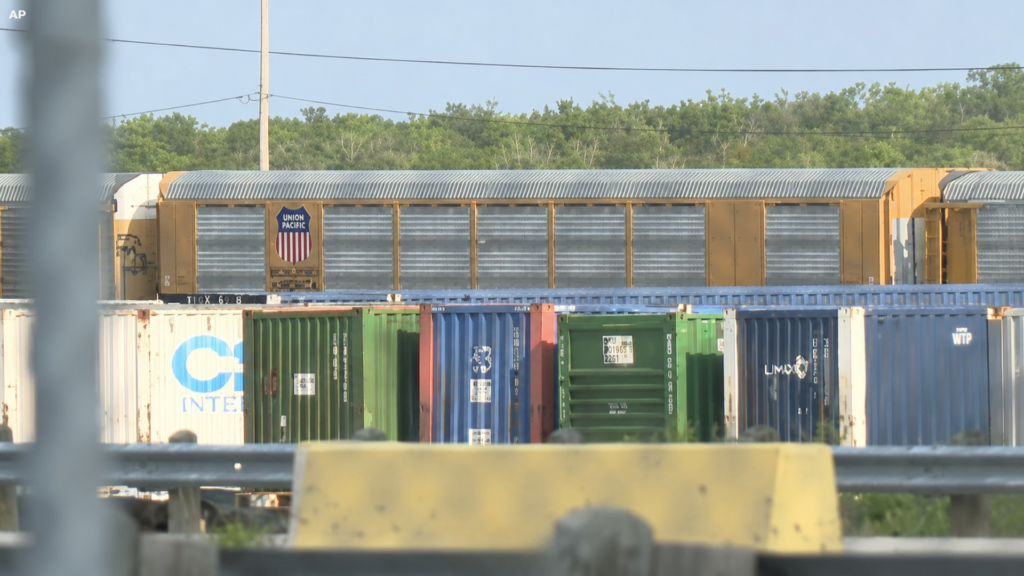 Union Pacific freight train and shipping containers at a rail yard.