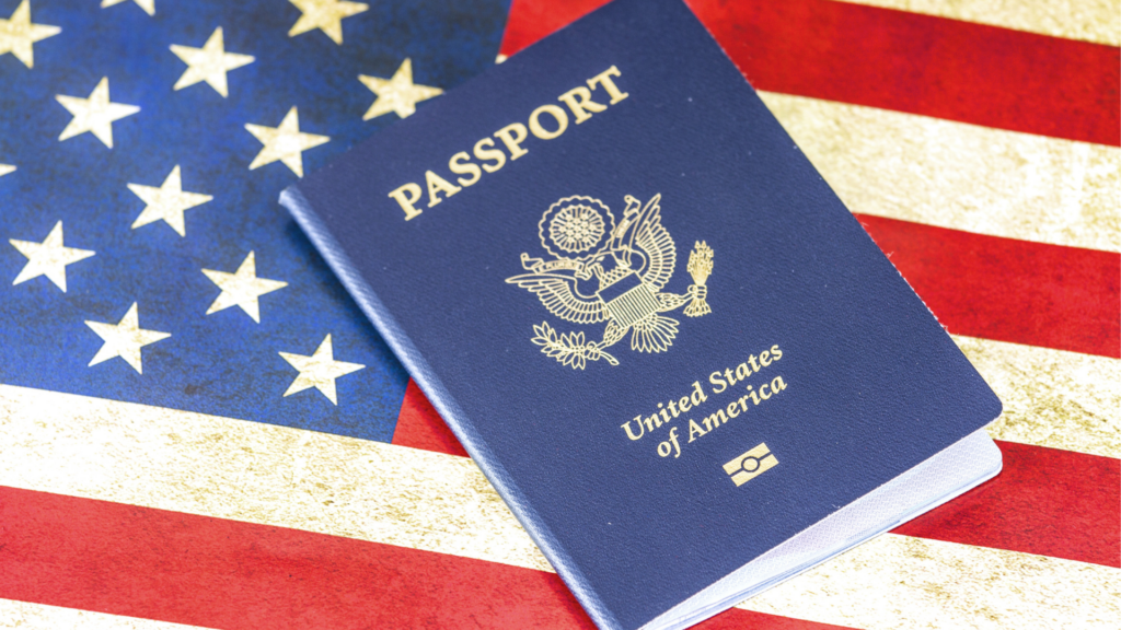 A dark blue United States passport resting on top of an American flag.