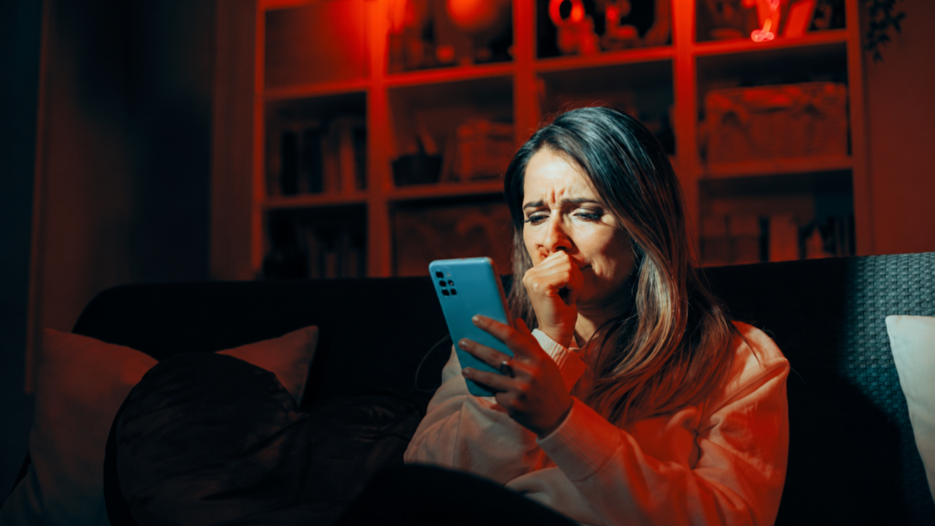 Woman looking concerned while reading information on her smartphone at home.