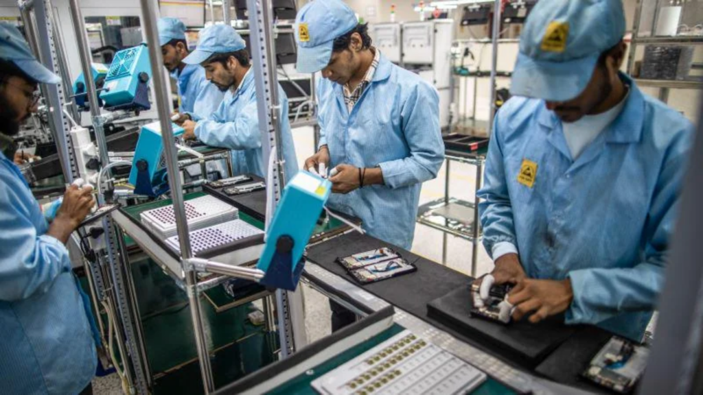 Factory workers assembling electronic devices on a production line.