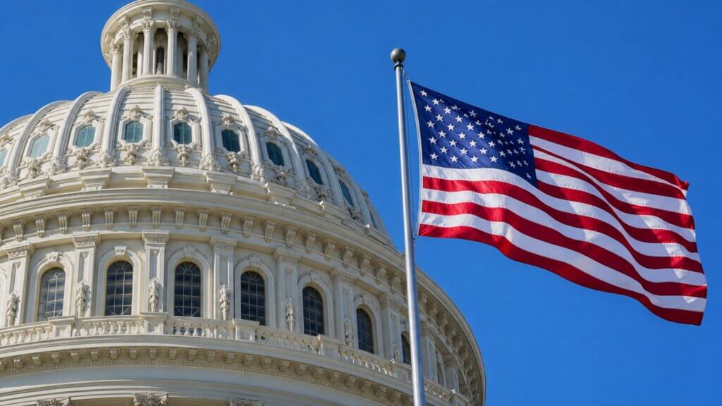 United States Capitol dome beside an American flag waving against a clear blue sky, highlighting the government oversight and policy context of the silicon six tax issue.