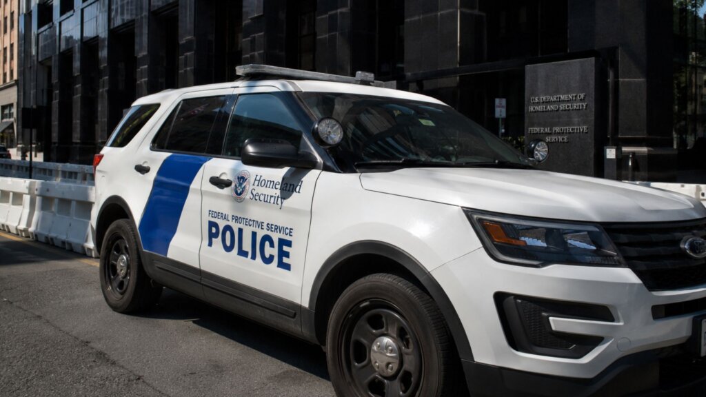 White Homeland Security Federal Protective Service police SUV parked outside a government building.