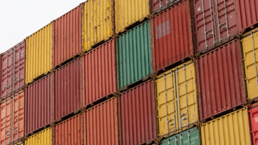 Stacks of multicolored shipping containers at a cargo storage facility.