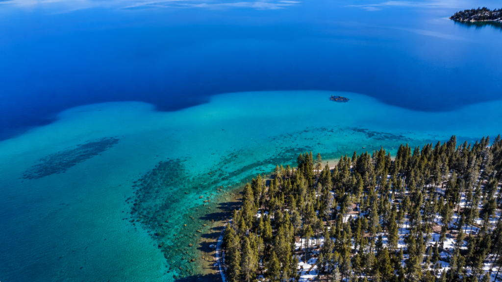 Aerial view of Lake Tahoe’s blue water and forested shoreline.