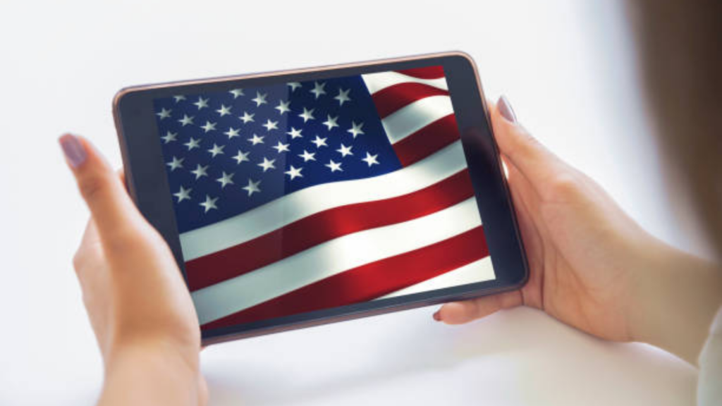 Hands holding a tablet displaying the American flag.