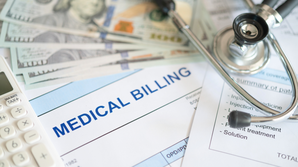 A close-up of a medical billing form, a stethoscope, a calculator, and hundred-dollar bills.