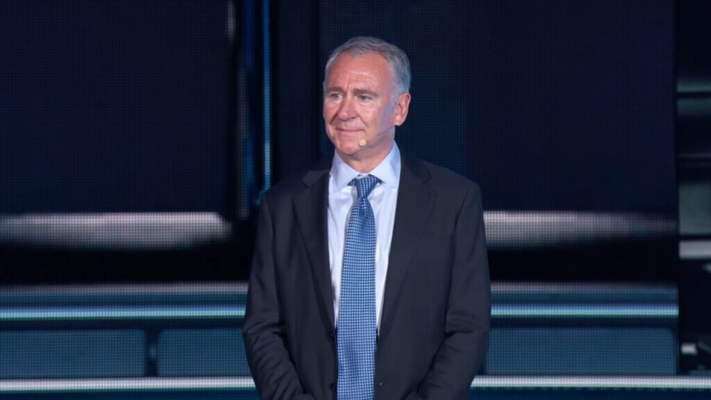 Ken Griffin standing on stage in a suit during a public speaking event.