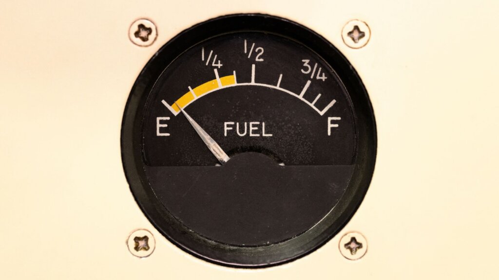 A fuel dashboard section displaying a critically low fuel level, with the gauge needle close to empty and warning indicators.
