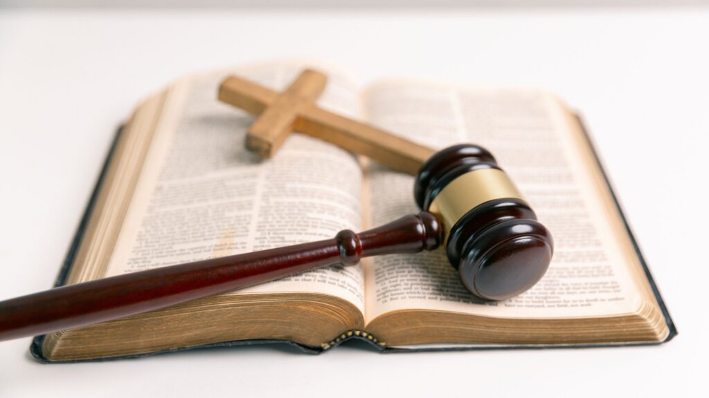 The bible with a cross and a hammer of the law.