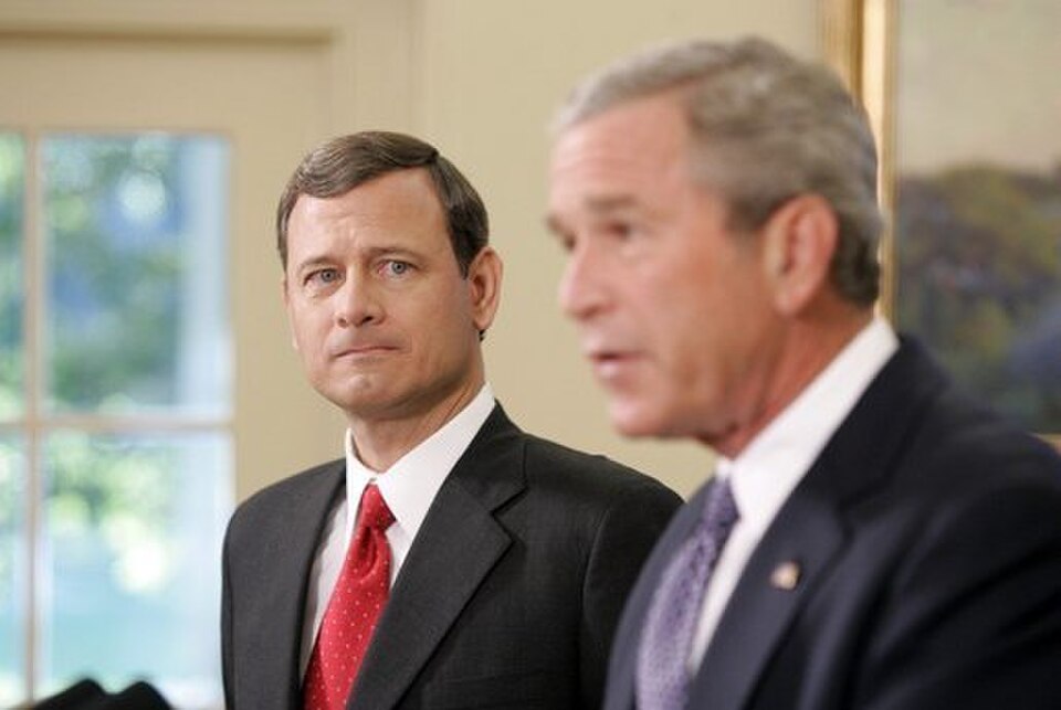 Chief Justice John Roberts listening as President George W. Bush speaks during a White House event.