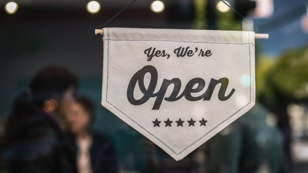 Open sign hanging in a small business storefront window.