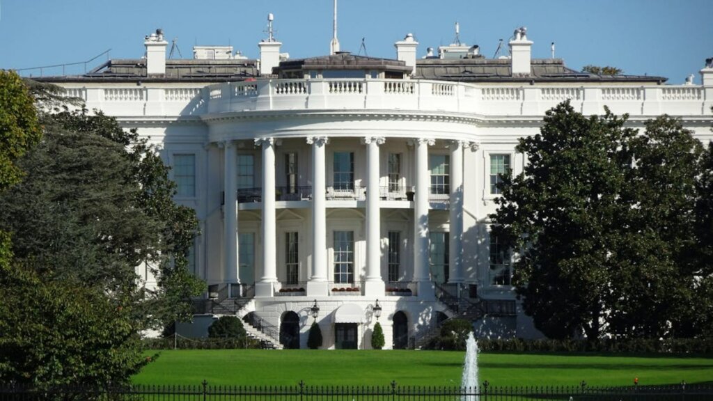 Front view of the White House in Washington, DC, showing its lawn and fountain.