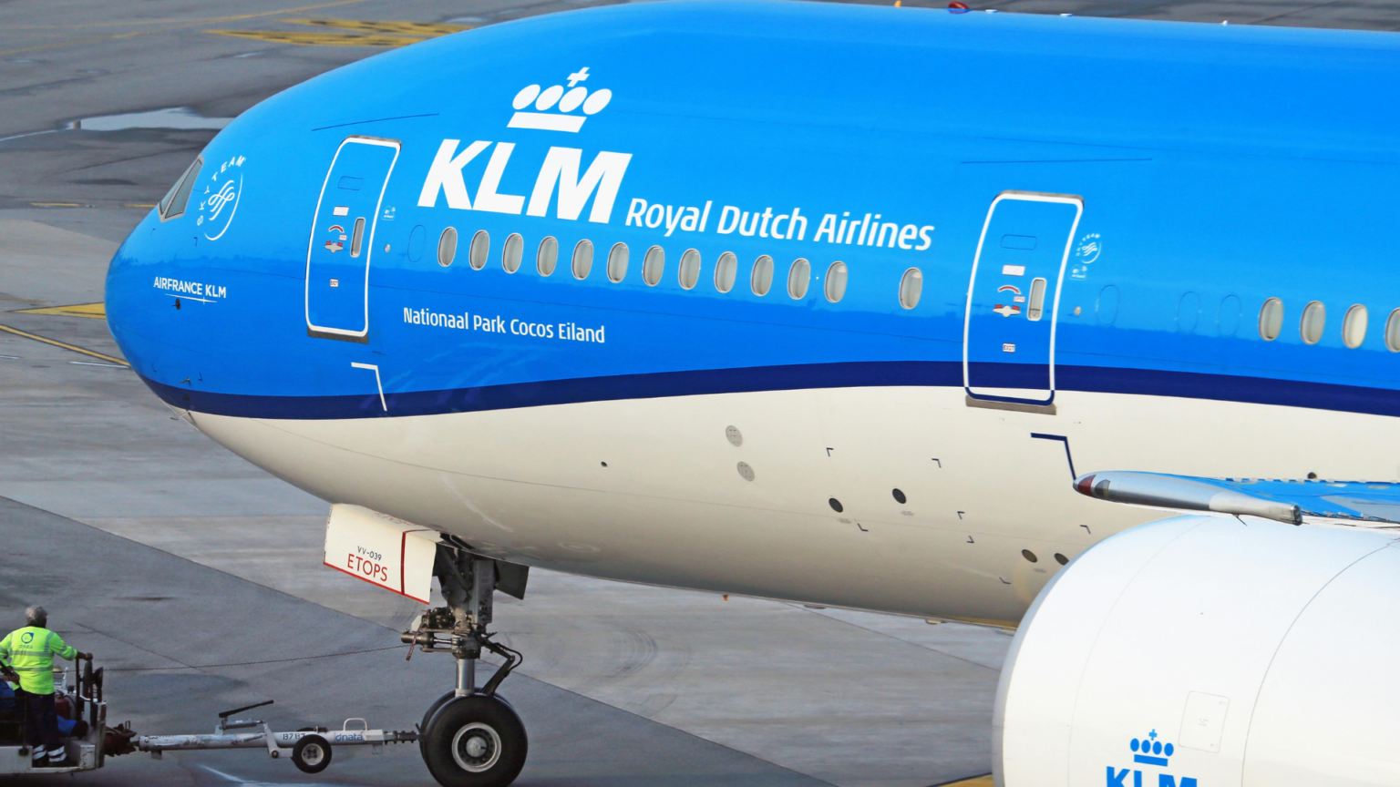 A close-up profile of the front of a KLM Royal Dutch Airlines airplane, showing its distinctive bright blue upper fuselage and white lower section.