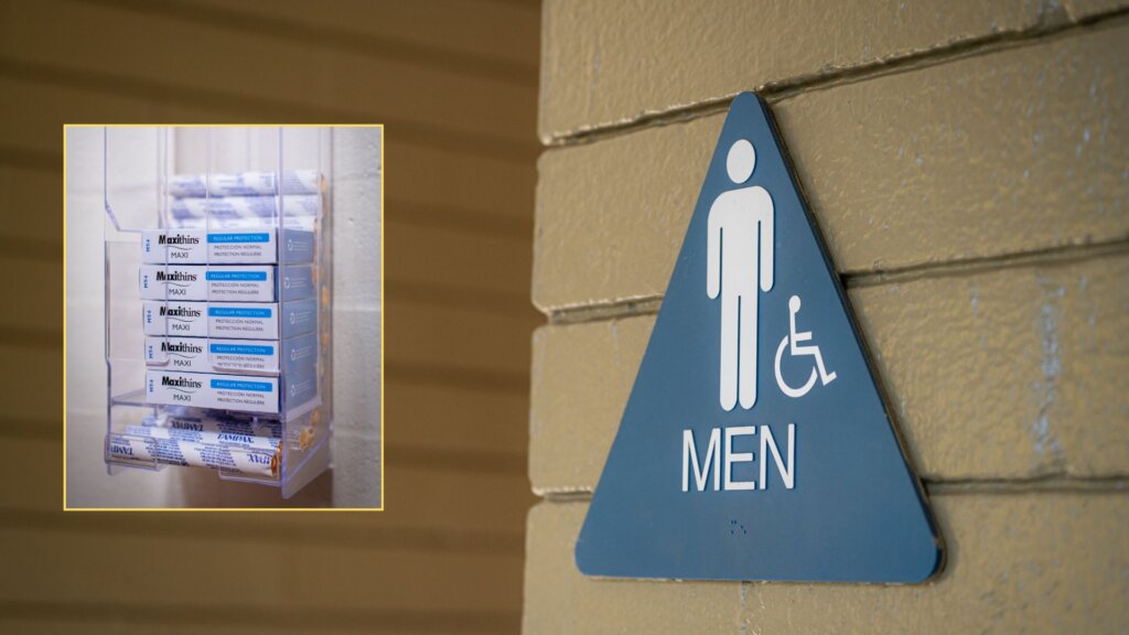 Blue men's restroom sign on brick wall with tampon dispenser inset.