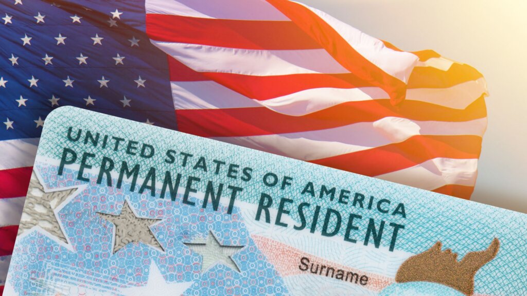 United States permanent resident card against a waving American flag.