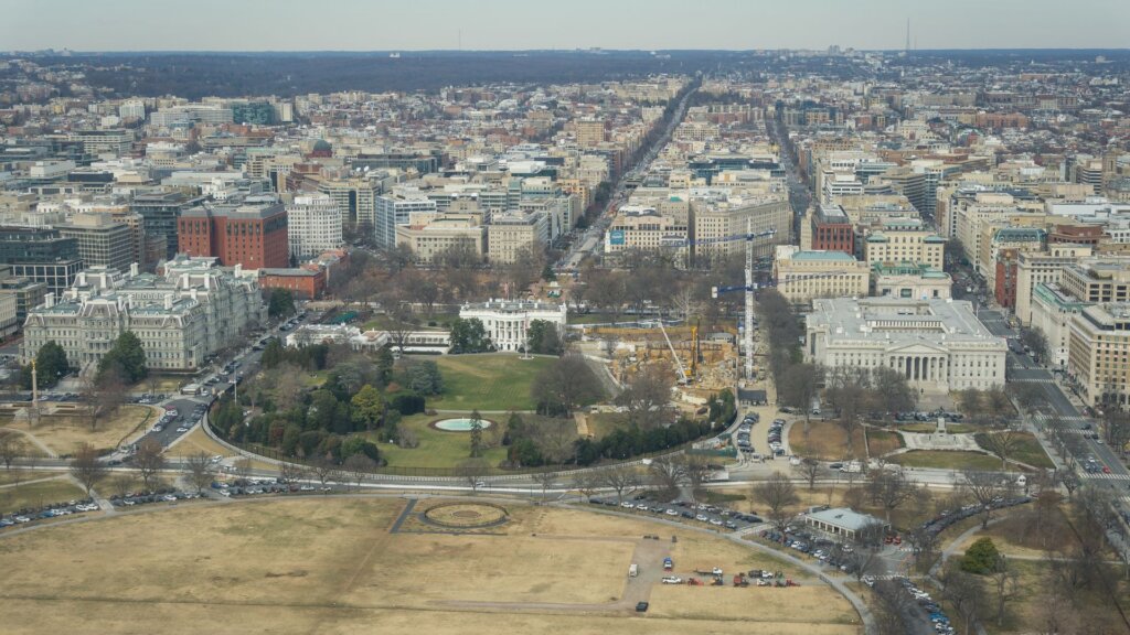 Aerial view of White House complex with East Wing construction crane visible.