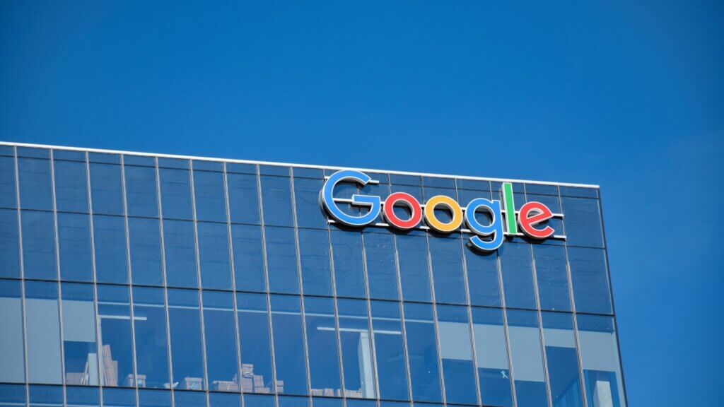 Building with the Google logo on its glass exterior against a clear blue sky.