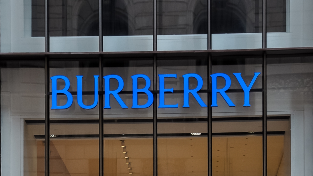 The glass-front facade of a modern, multi-story Burberry flagship boutique.