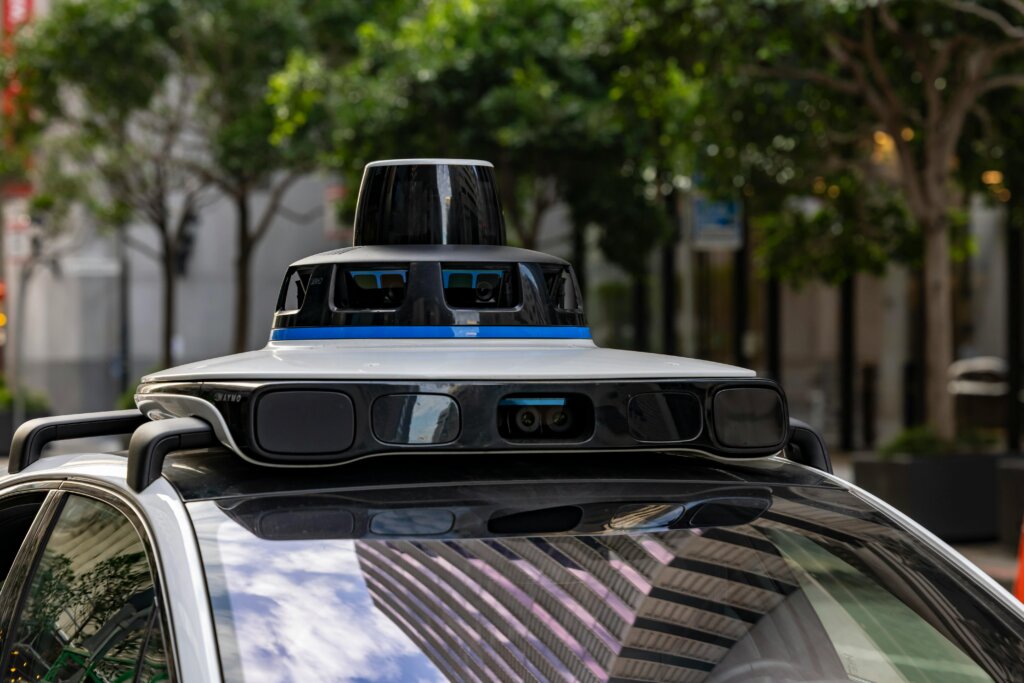 Sensors and cameras mounted on top of a self-driving vehicle in a city street.
