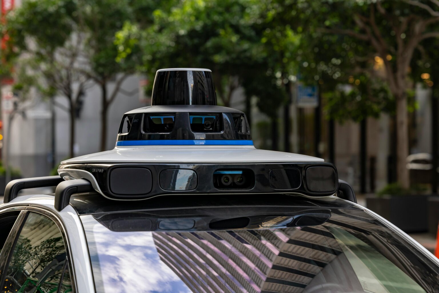 Sensors and cameras mounted on top of a self-driving vehicle in a city street.
