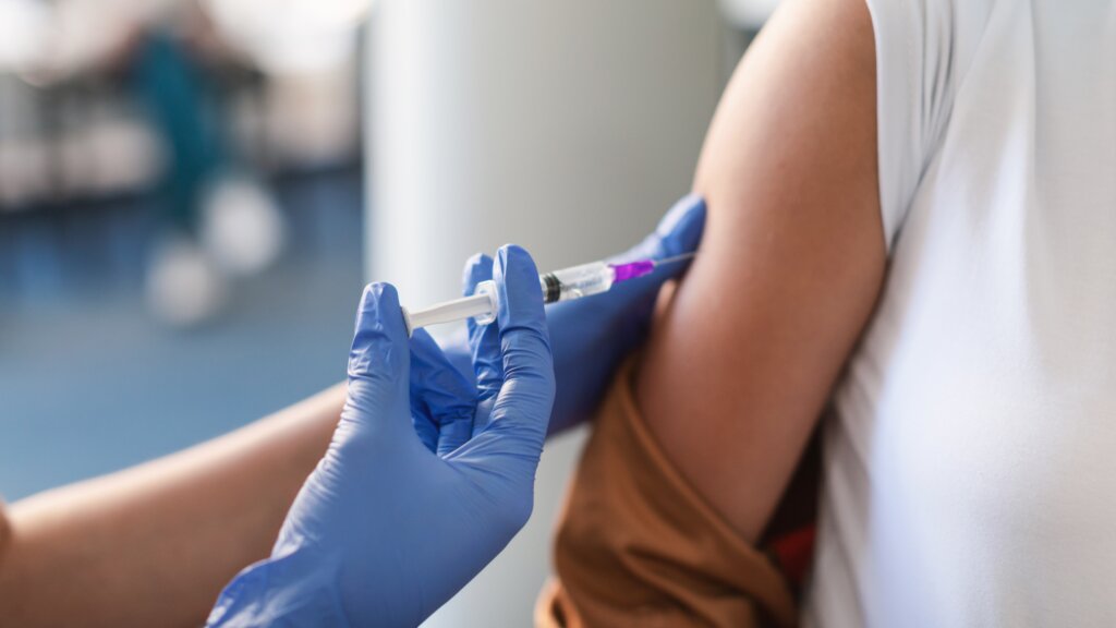 Healthcare worker administering a vaccine injection to a patient.