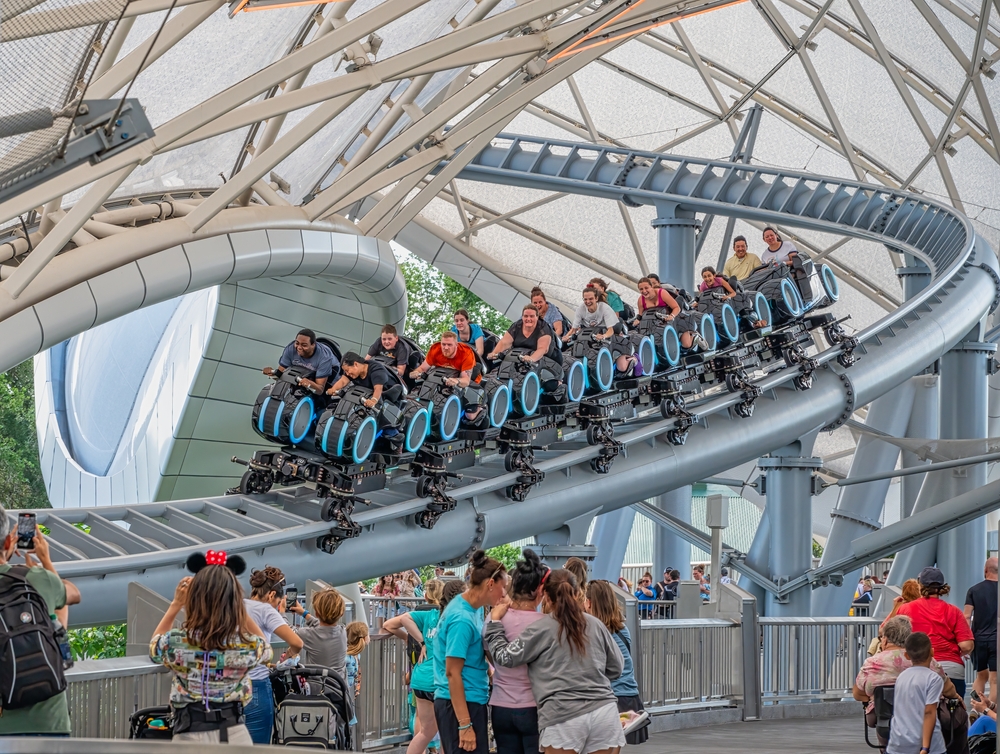People riding the Tron Lightcycle Run roller coaster at Disneyland.