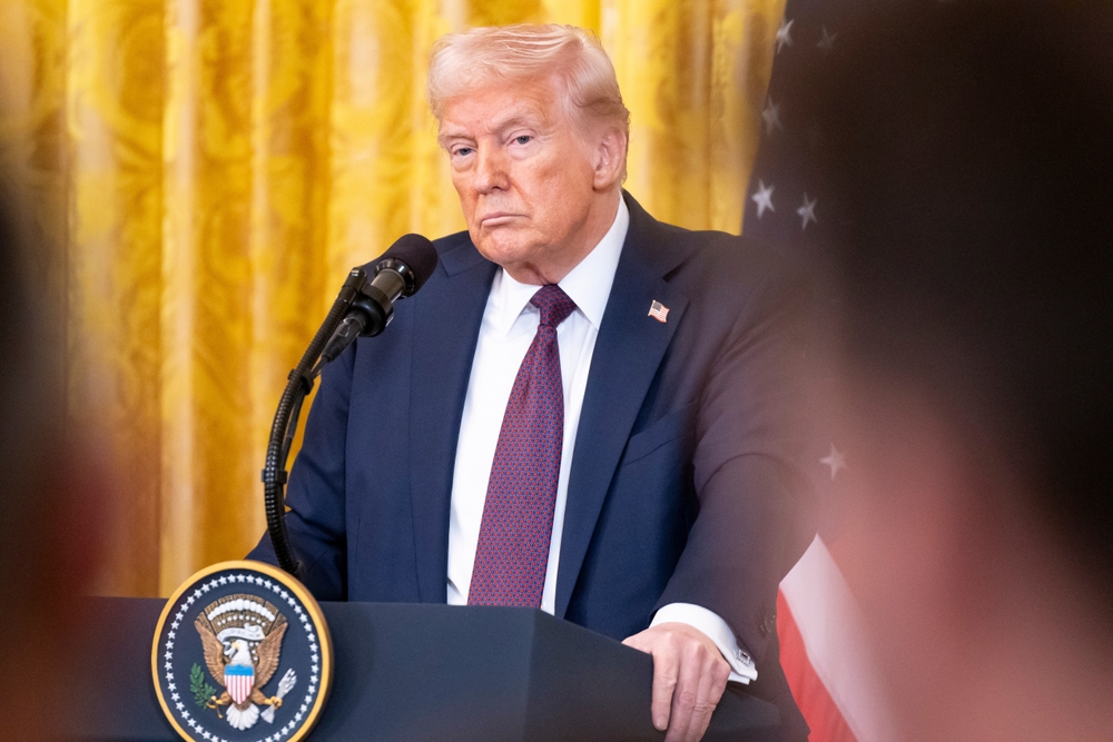 President Donald Trump speaking at a White House event behind a presidential podium.