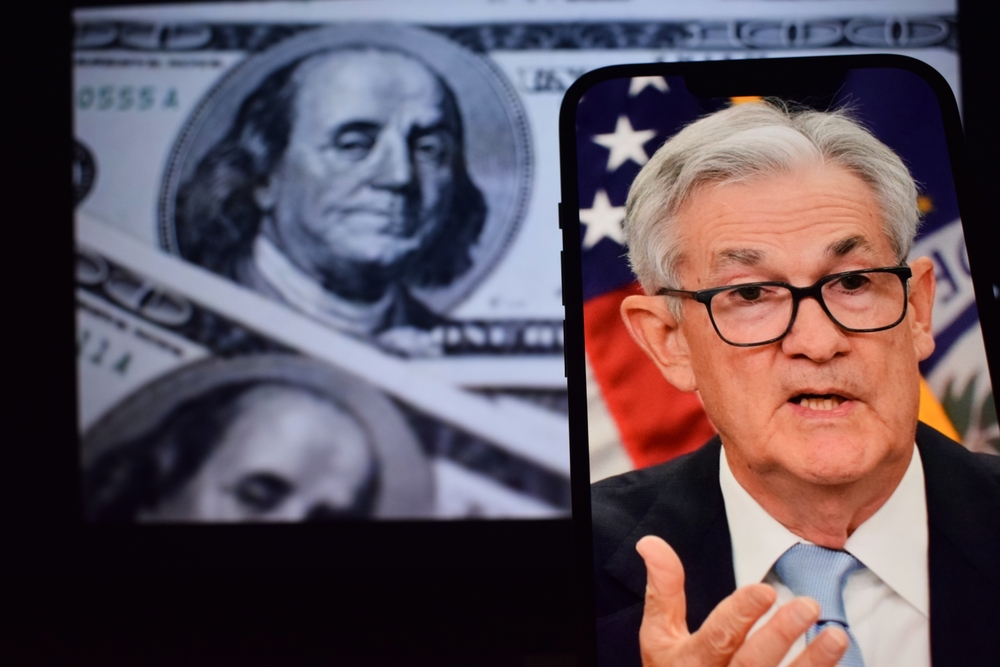 Federal Reserve Chair Jerome Powell pictured alongside U.S. dollar imagery.
