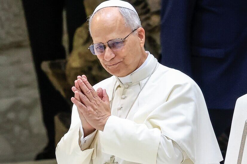 Pope Francis greeting attendees in white papal robes.