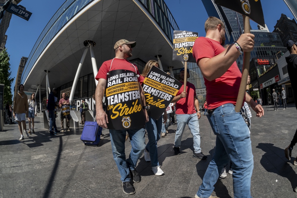 Long Island Rail Road workers carry Teamsters strike signs outside Penn Station during the LIRR strike in Manhattan.