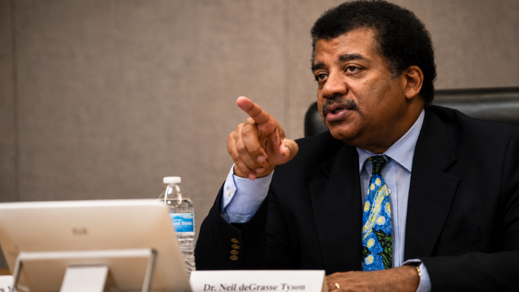 Neil deGrasse Tyson speaking and pointing during a meeting.