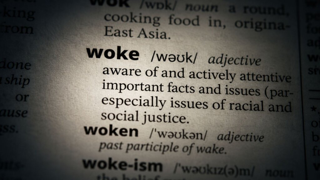 Close up of a dictionary entry showing the word "woke" with the definition "aware of and actively attentive to important facts and issues especially issues of racial and social justice."