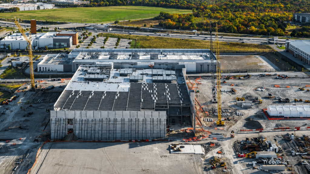 Aerial view of a data center construction site with cranes and heavy equipment.