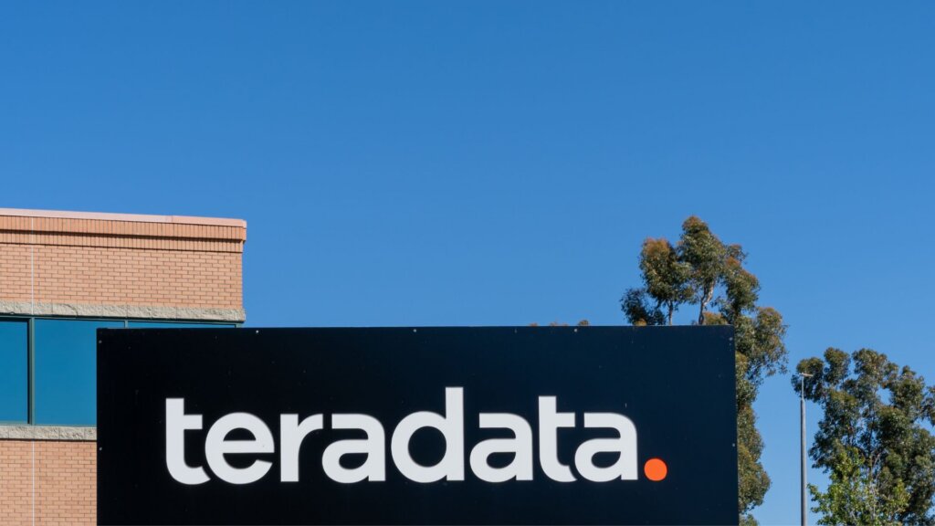 Sign displaying the Teradata logo outside a corporate office building under a clear blue sky.
