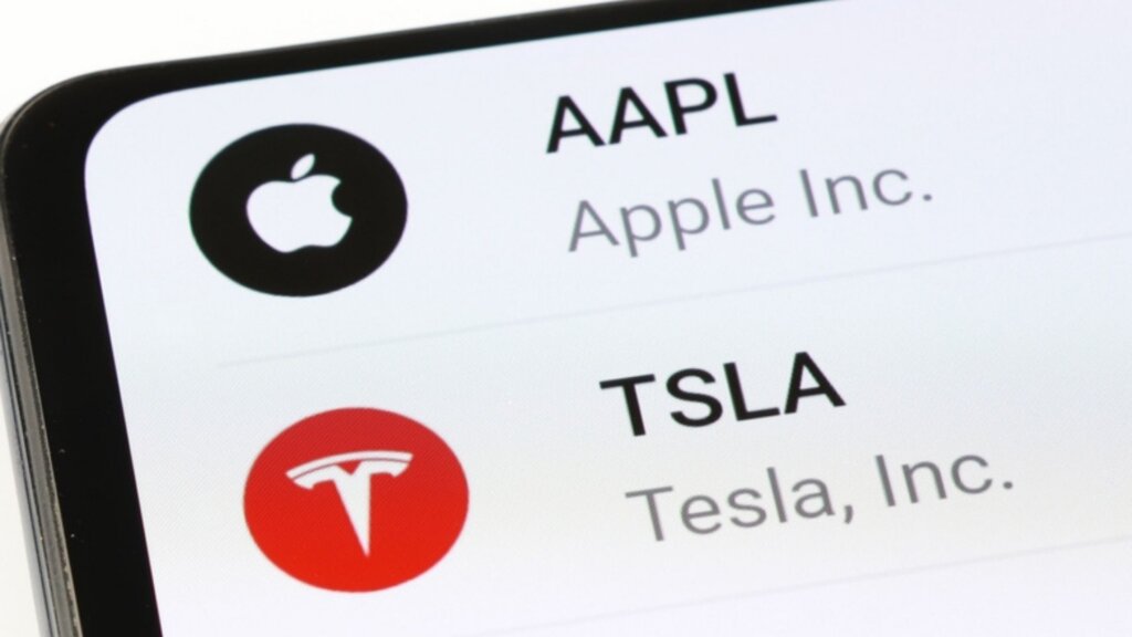 Apple and Tesla stock symbols displayed on a smartphone screen with their company logos.
