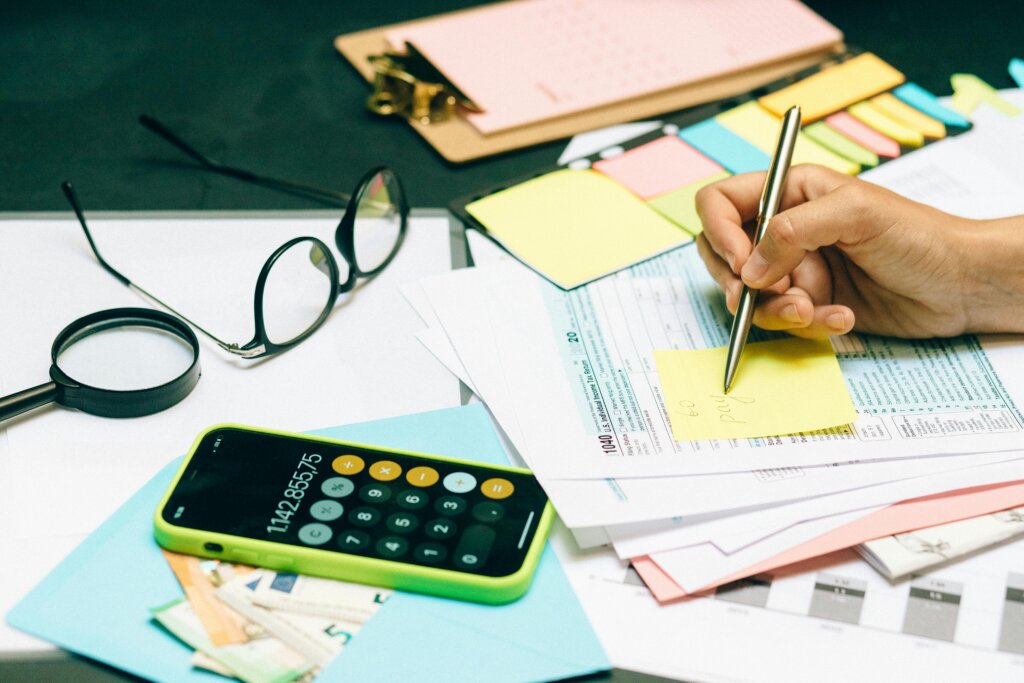 Budgeting and tax paperwork with calculator, notes, and cash on a desk.