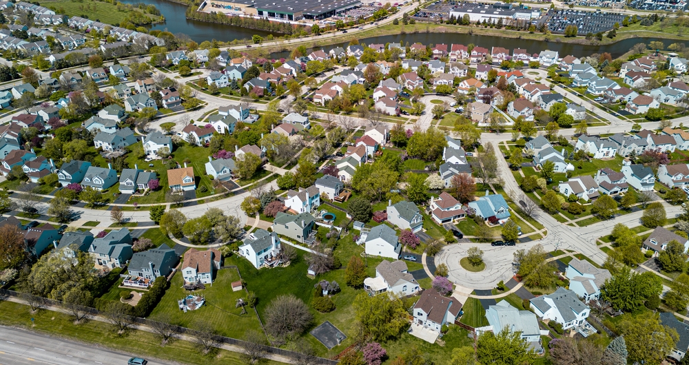 Aerial view of a suburban neighborhood with single-family homes, winding streets, and landscaped yards.